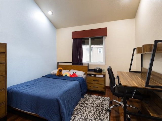 bedroom featuring lofted ceiling and wood finished floors