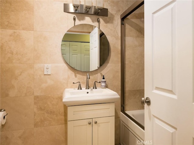 full bath with backsplash, shower / tub combination, vanity, and tile walls