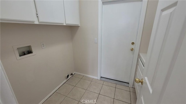 washroom featuring cabinet space, baseboards, light tile patterned floors, and washer hookup