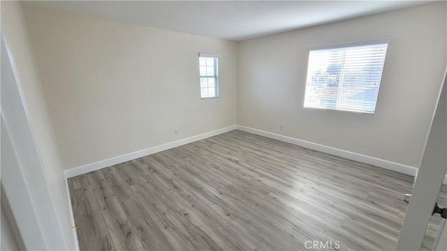 unfurnished room featuring light wood-style flooring and baseboards