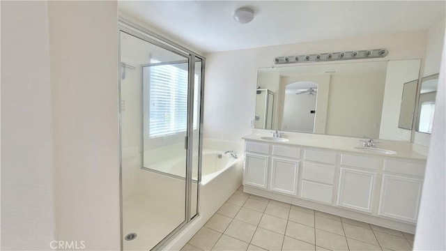 full bathroom featuring a wealth of natural light, a shower stall, a garden tub, and a sink