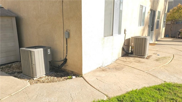 view of side of home featuring cooling unit and stucco siding