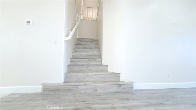 stairway featuring wood finished floors and baseboards