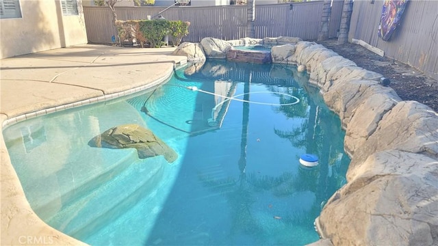 view of swimming pool with an outdoor hot tub, fence, and a fenced in pool