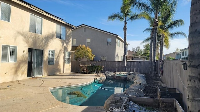 view of swimming pool featuring a patio area, a fenced backyard, and a pool with connected hot tub