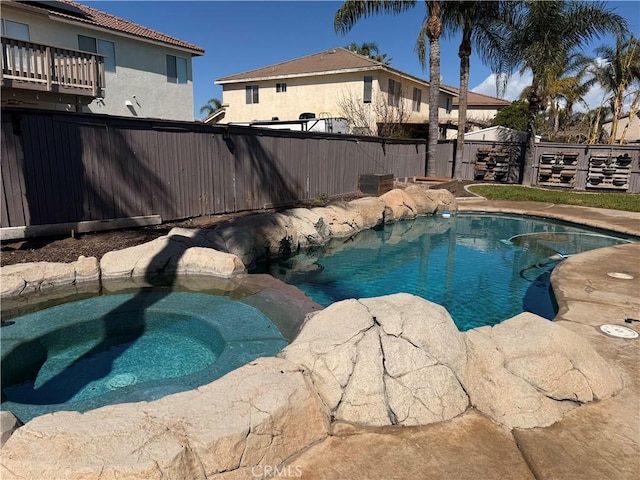 view of swimming pool with a fenced in pool, a fenced backyard, and an in ground hot tub