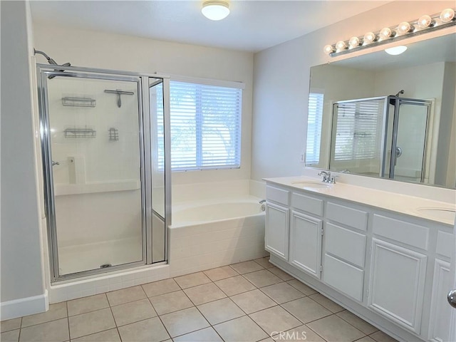 full bathroom with a stall shower, a garden tub, a sink, and tile patterned floors