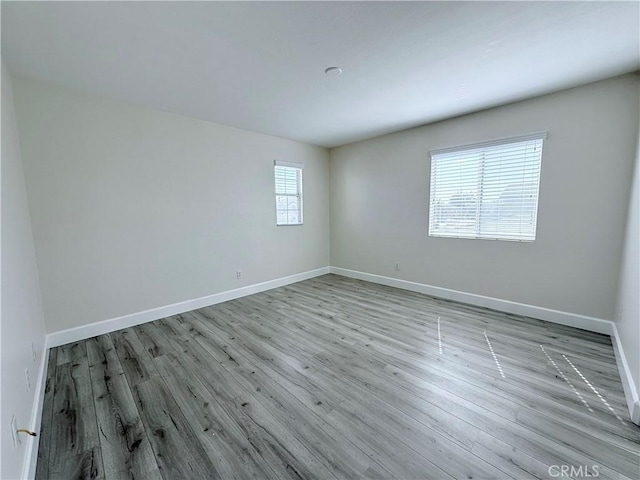 spare room featuring wood finished floors and baseboards