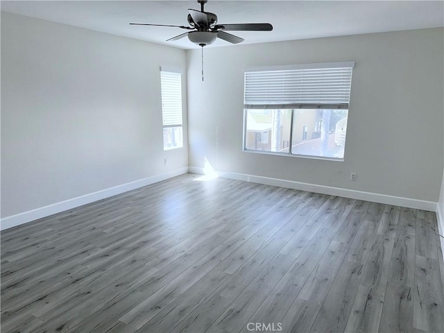 unfurnished room with ceiling fan, baseboards, and wood finished floors