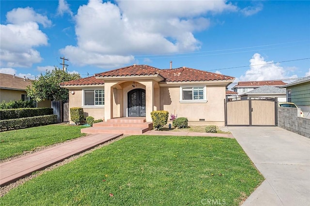 mediterranean / spanish-style house featuring a tile roof, a gate, and stucco siding