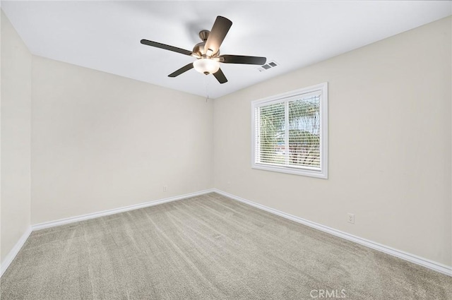 spare room with carpet, visible vents, ceiling fan, and baseboards