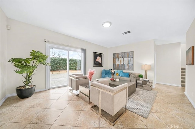 living area with stairs, light tile patterned floors, visible vents, and baseboards