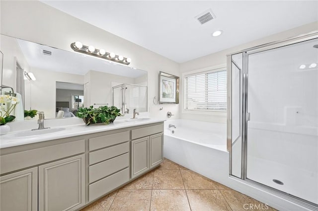 bathroom with a stall shower, visible vents, and a sink