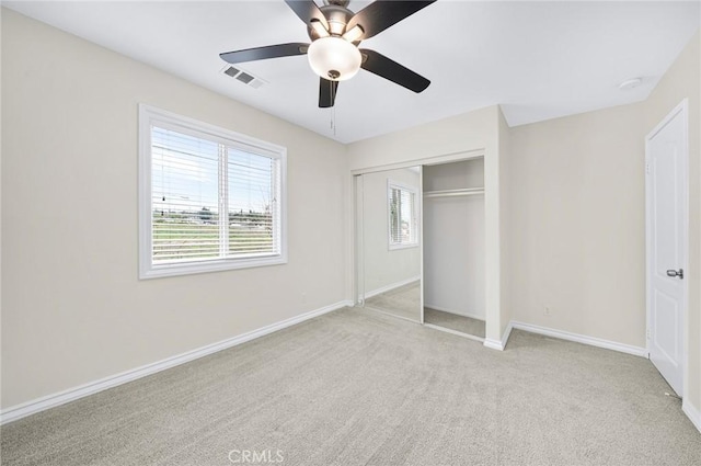 unfurnished bedroom featuring carpet floors, multiple windows, a closet, and visible vents