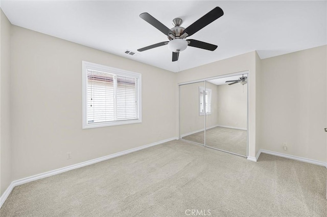 unfurnished bedroom featuring ceiling fan, carpet floors, visible vents, baseboards, and a closet