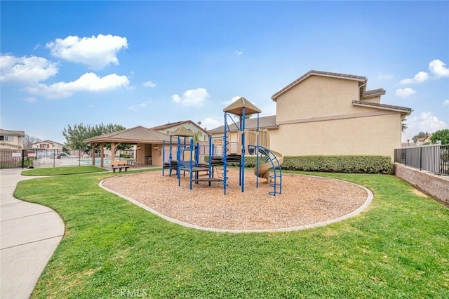 community play area featuring a yard and fence