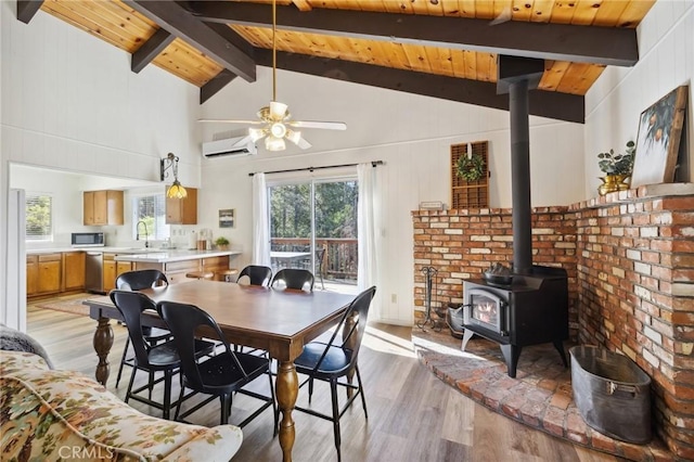 24950 Roble Dr, Idyllwild, CA 92549 - dining space featuring wood ceiling, a wall mounted air conditioner, a wood stove, light wood-style floors, and beam ceiling