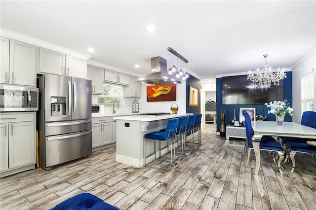 kitchen with ornamental molding, appliances with stainless steel finishes, a breakfast bar area, and island range hood