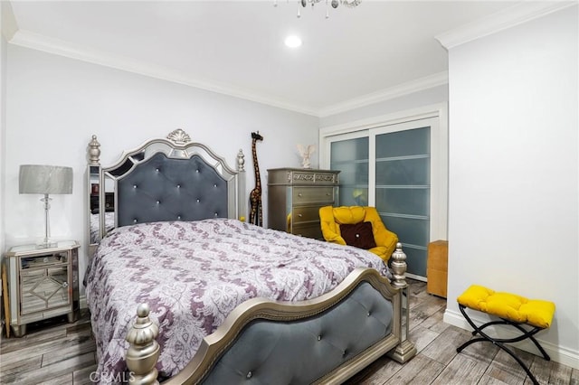 bedroom featuring baseboards, ornamental molding, and wood tiled floor