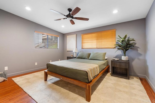 bedroom with light wood finished floors, baseboards, vaulted ceiling, and recessed lighting