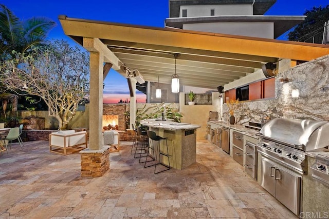 view of patio / terrace with outdoor dry bar, area for grilling, and a grill