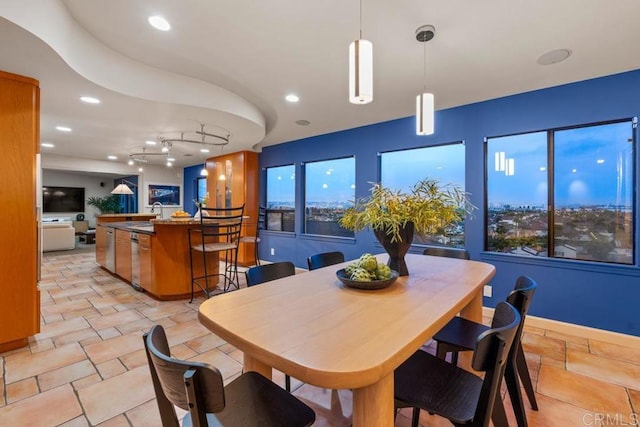 dining space with a wealth of natural light, baseboards, stone tile flooring, and recessed lighting