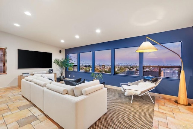 living room with recessed lighting, baseboards, vaulted ceiling, and stone tile floors