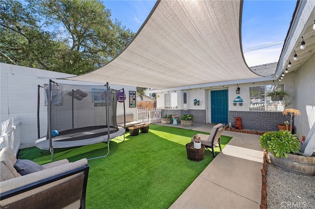 view of patio featuring a trampoline and fence