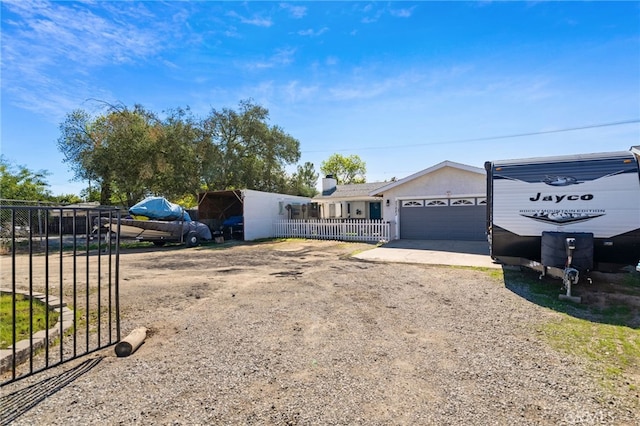 ranch-style house featuring a garage, driveway, and fence