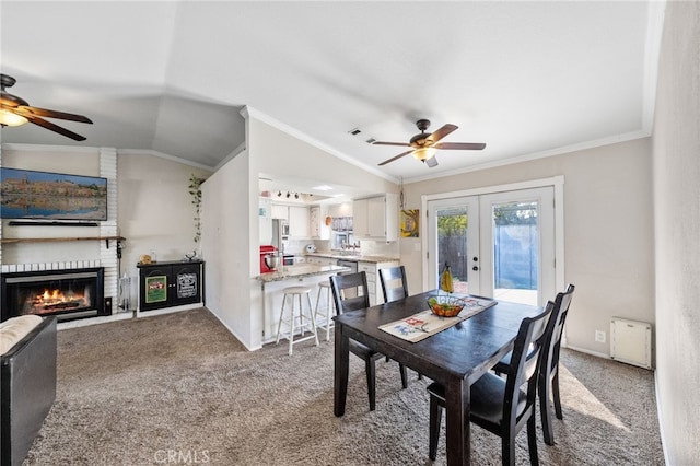 23883 Vista Way, Menifee, CA 92587 - carpeted dining area featuring a ceiling fan, french doors, crown molding, a brick fireplace, and vaulted ceiling