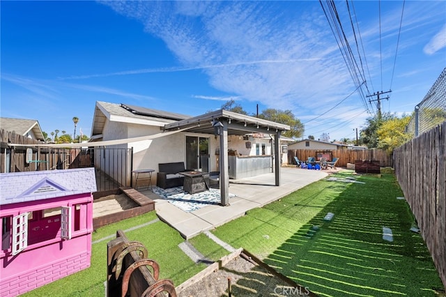 23883 Vista Way, Menifee, CA 92587 - back of house featuring a fire pit, stucco siding, a patio area, roof mounted solar panels, and a fenced backyard