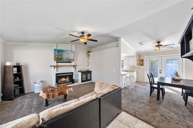 living room featuring a fireplace, ornamental molding, french doors, and light colored carpet