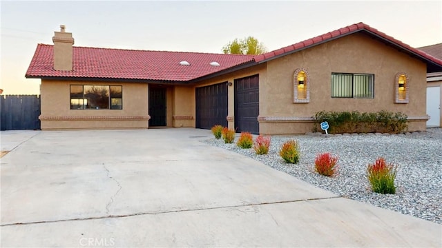 ranch-style home with an attached garage, stucco siding, a chimney, concrete driveway, and a tile roof