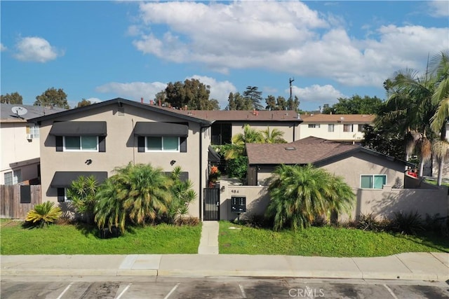 view of front of property featuring a fenced front yard, a gate, and stucco siding