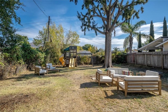 view of yard with an outdoor hangout area, a playground, and fence