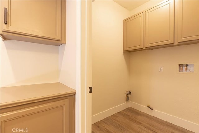 clothes washing area featuring hookup for a washing machine, light wood-style flooring, baseboards, cabinet space, and gas dryer hookup