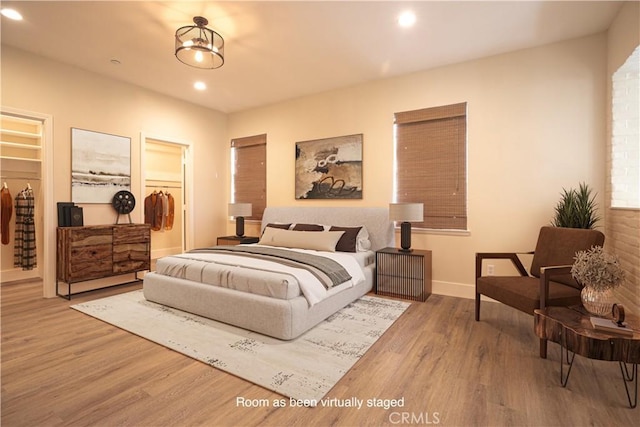 bedroom featuring baseboards, wood finished floors, and recessed lighting