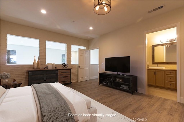 bedroom featuring visible vents, recessed lighting, light wood-style floors, and a sink