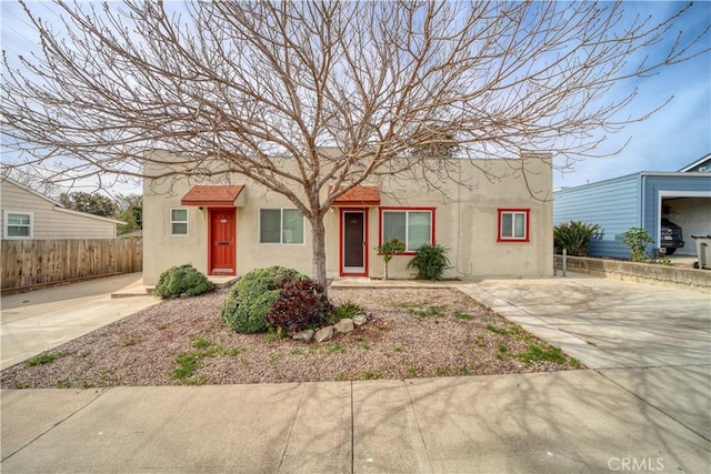 view of front facade featuring fence and stucco siding