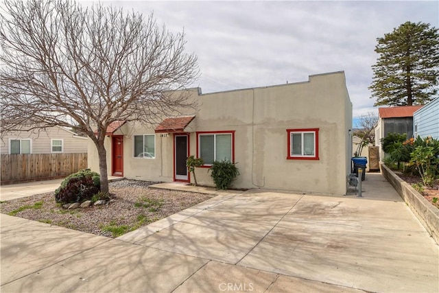 view of front of house with fence and stucco siding