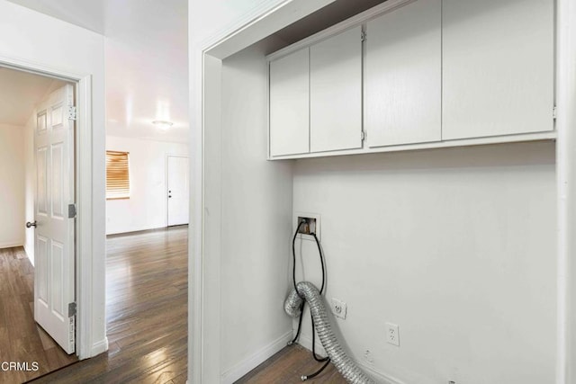 clothes washing area with dark wood-style floors, hookup for a washing machine, cabinet space, and baseboards