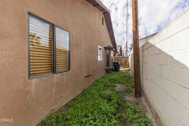 view of property exterior with fence and stucco siding