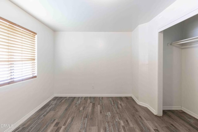 unfurnished bedroom featuring a closet, baseboards, and wood finished floors