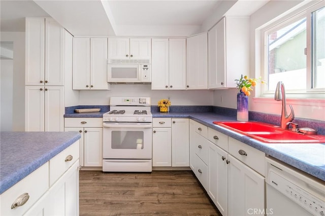 kitchen featuring white appliances, white cabinetry, dark wood-style flooring, and a sink