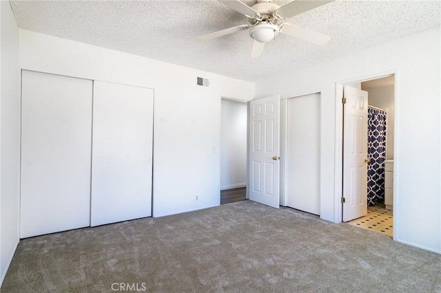 unfurnished bedroom with a closet, visible vents, carpet flooring, connected bathroom, and a textured ceiling