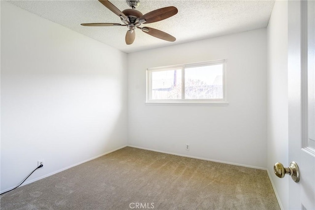 spare room featuring ceiling fan, a textured ceiling, baseboards, and carpet flooring