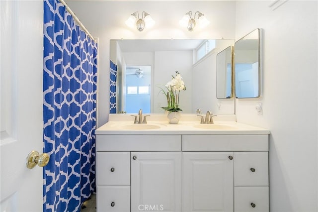 full bathroom featuring double vanity, a wealth of natural light, and a sink