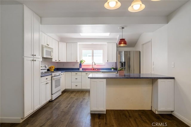 kitchen with dark countertops, white appliances, white cabinetry, and a sink