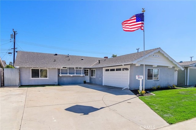 ranch-style house with a garage, a shingled roof, concrete driveway, a front yard, and stucco siding