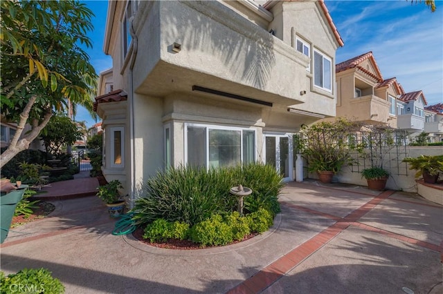 view of side of property featuring stucco siding and a residential view